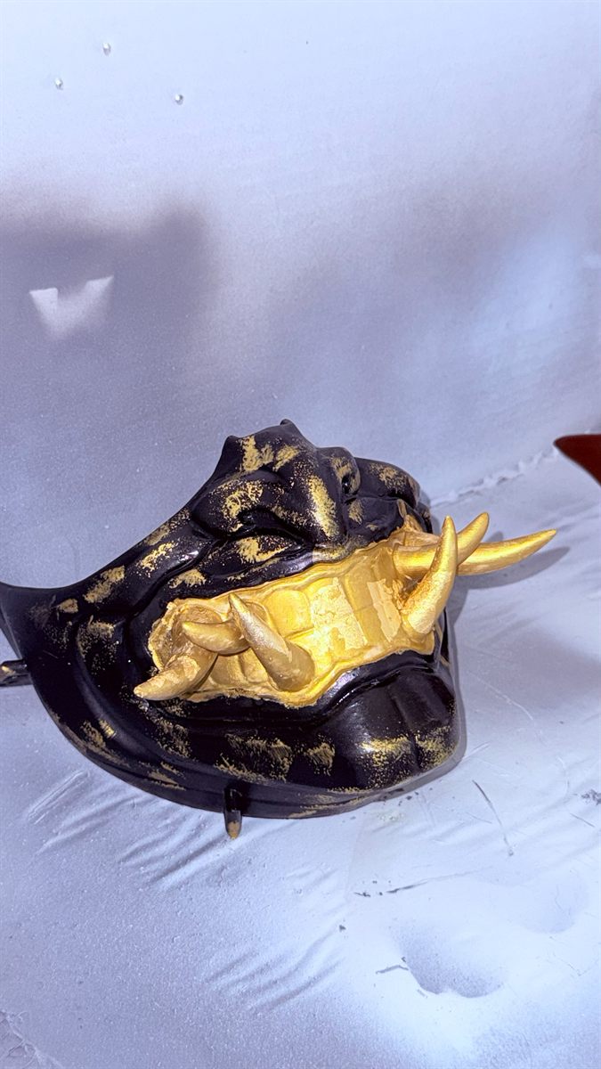Black and gold oni mask with gilded fangs