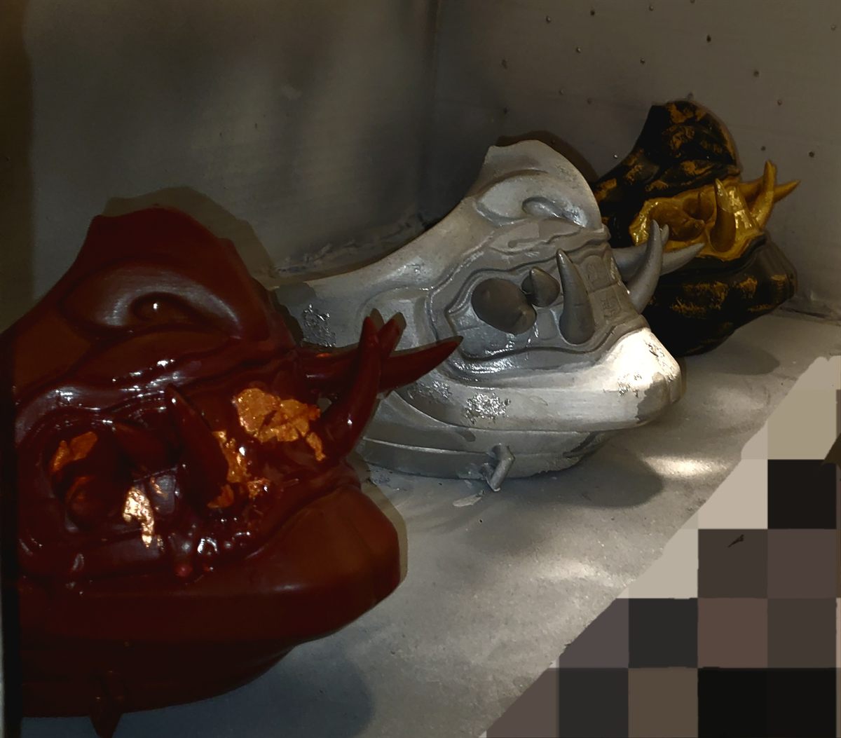 Three oni masks displayed from the side